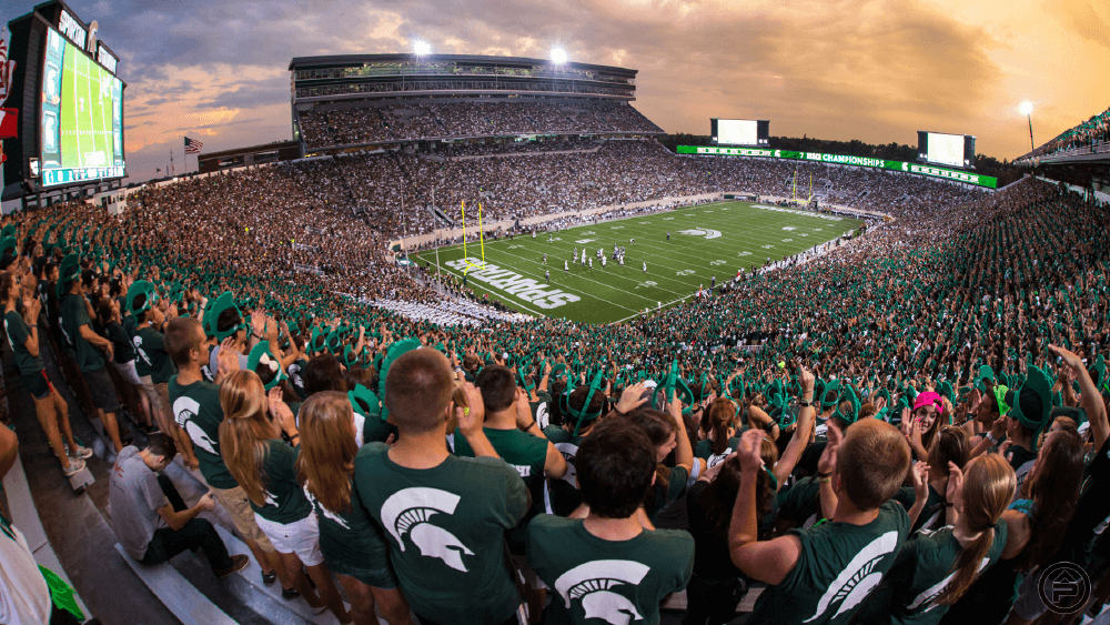 Football fans cheer on the Michigan State Spartans at Spartan Stadium in East Lansing.