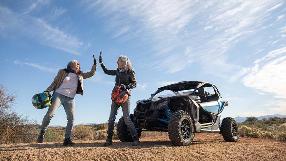 two people high-fiving near ATV
