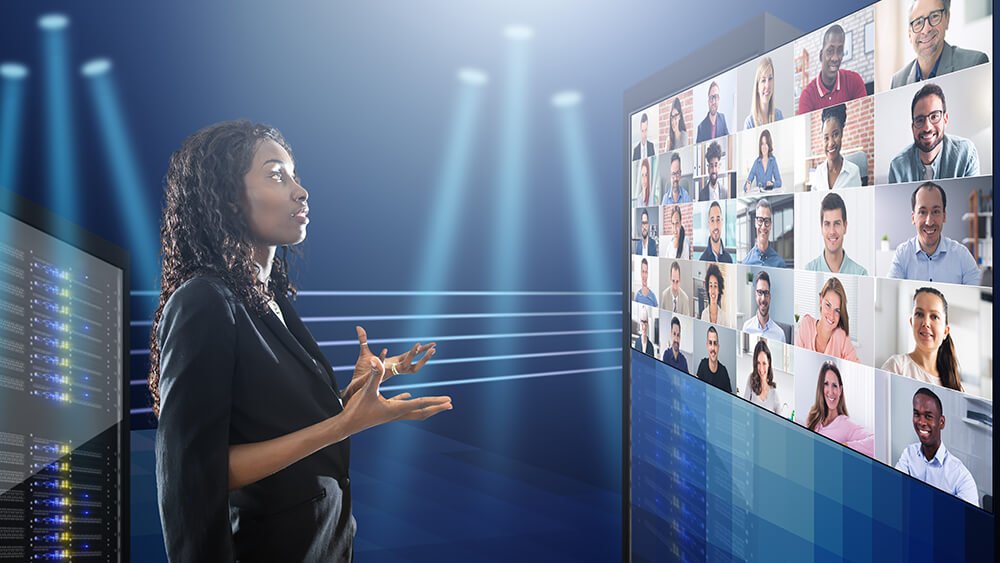 female speaker addressing virtual event participants on screen
