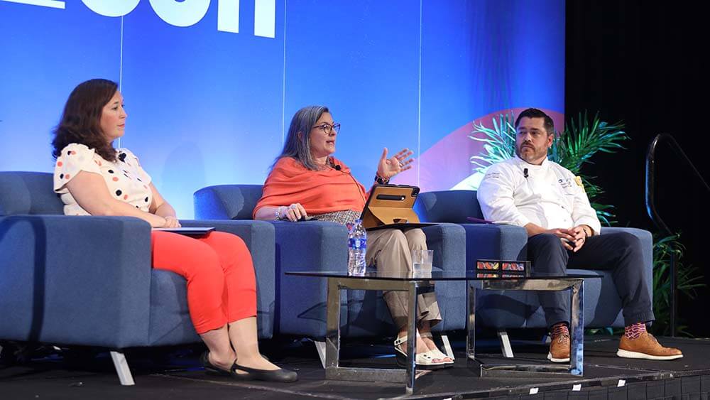3 panelists seated on EduCon stage