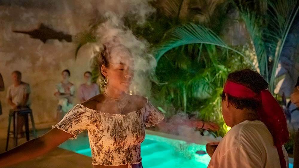 woman is blessed with smoke in shamanic ceremony