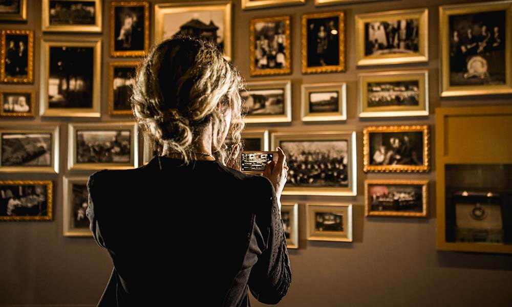 woman looking at photos on museum wall