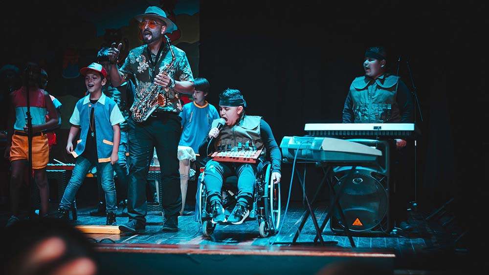 band on stage, one performer in wheelchair