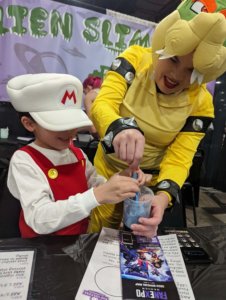 costumed child, parent doing experiment at Fan Expo