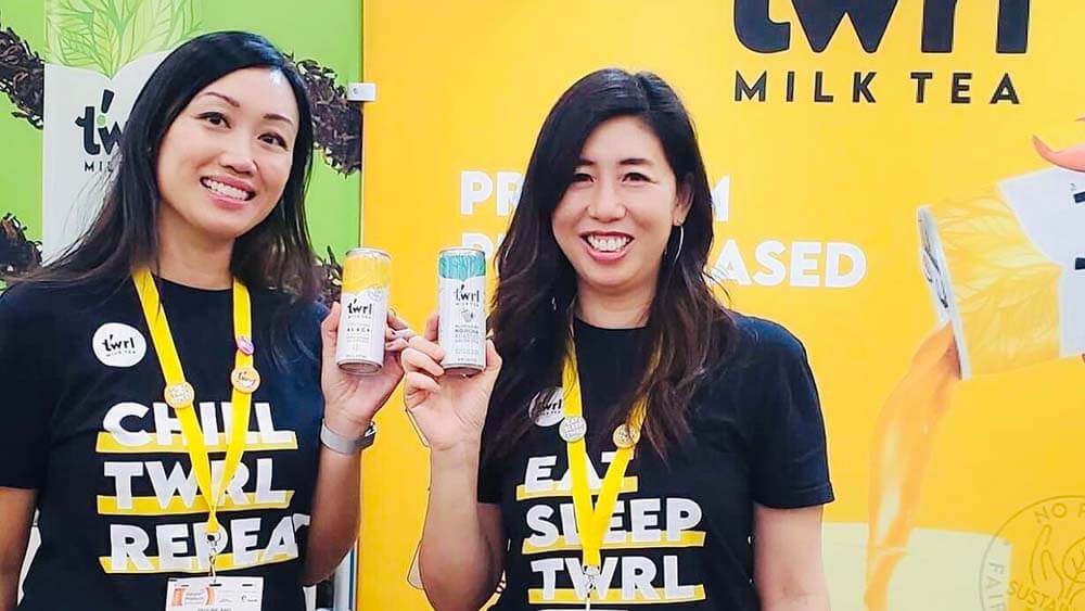 Pauline Ang and Olivia Chen hold cans of their prodcut, Twrl Milk Tea