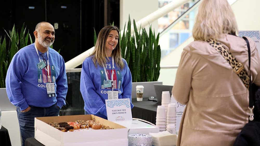 greeters providing snacks at event registration