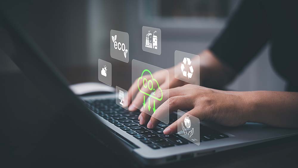 woman typing on laptop with C)2 and other environmental icons floating around hands