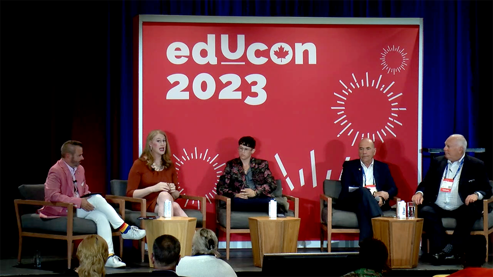 group of people on stage in panel with educon 2023 sign behind them