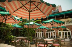 courtyard dining space with green and orange table umbrellas