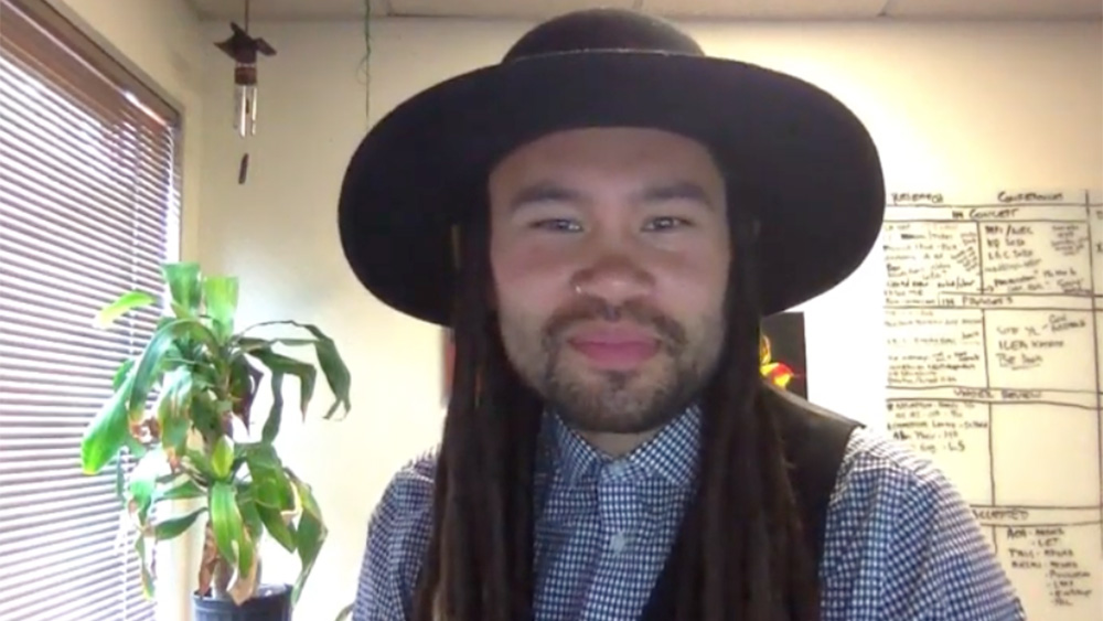 bearded Andrew Lacanienta with long dark hair wearing a round hat