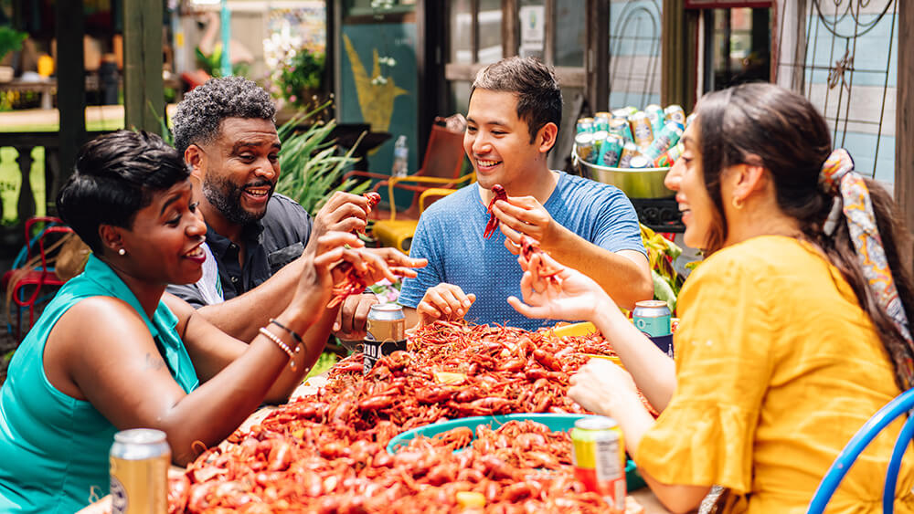 4 multicultural people eating crawfish