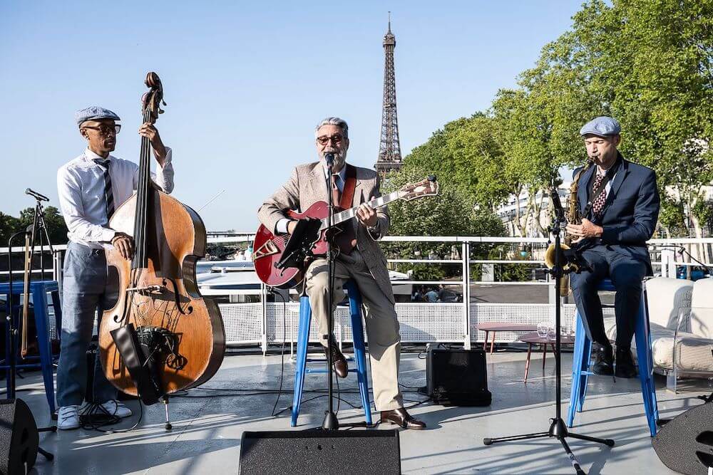 3-piece band plays on boat with Eiffel Tower in background