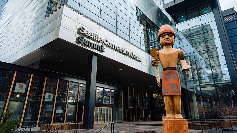 wooden statue in front of glass building