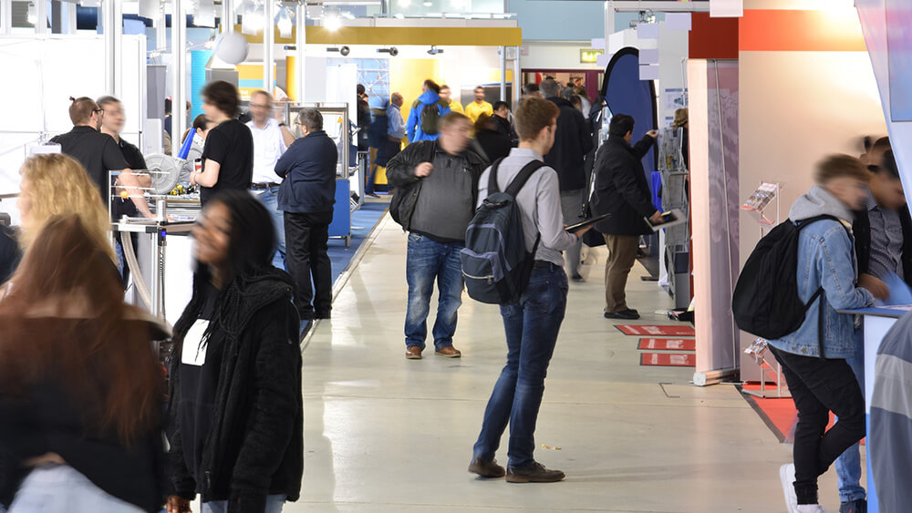 trade show attendees looking at exhibitor booths