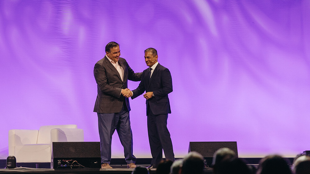 two men shaking hands on stage