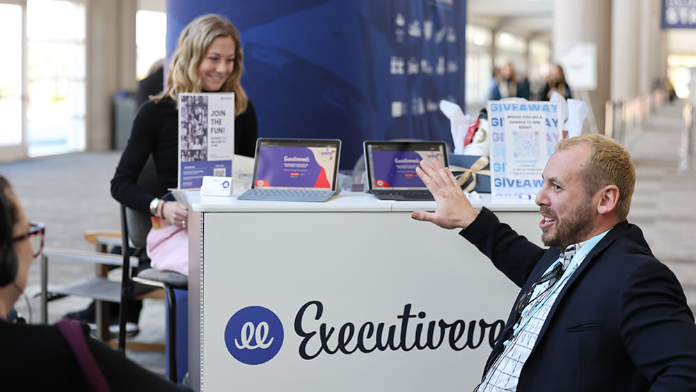 man in wheelchair in front of expo booth talking