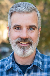 caucasian man graying beard and hair blue eyes