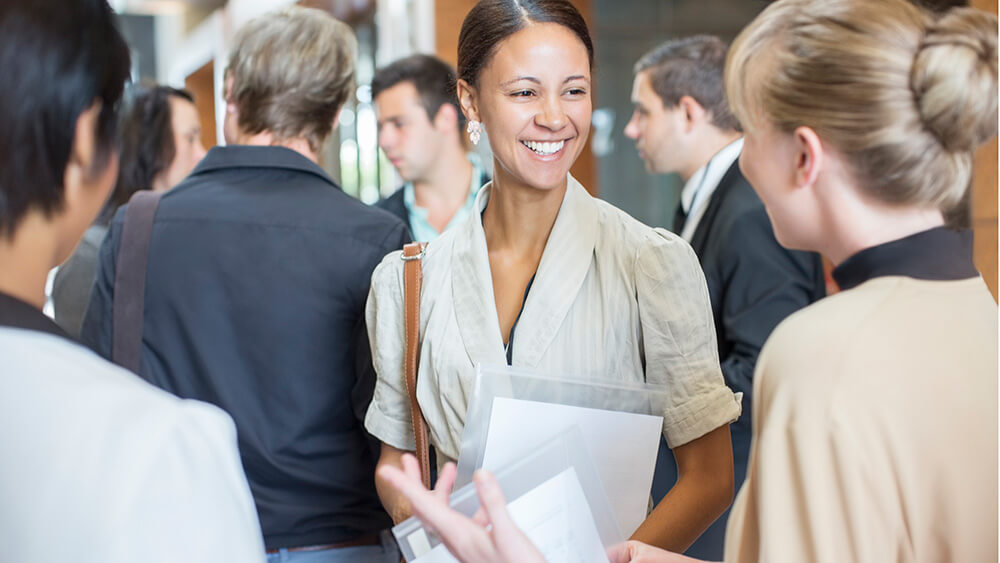 smiling woman greeting others at meeting