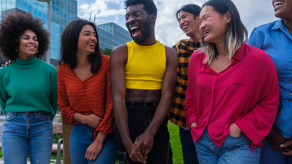 A group of diverse young people laughing together outside