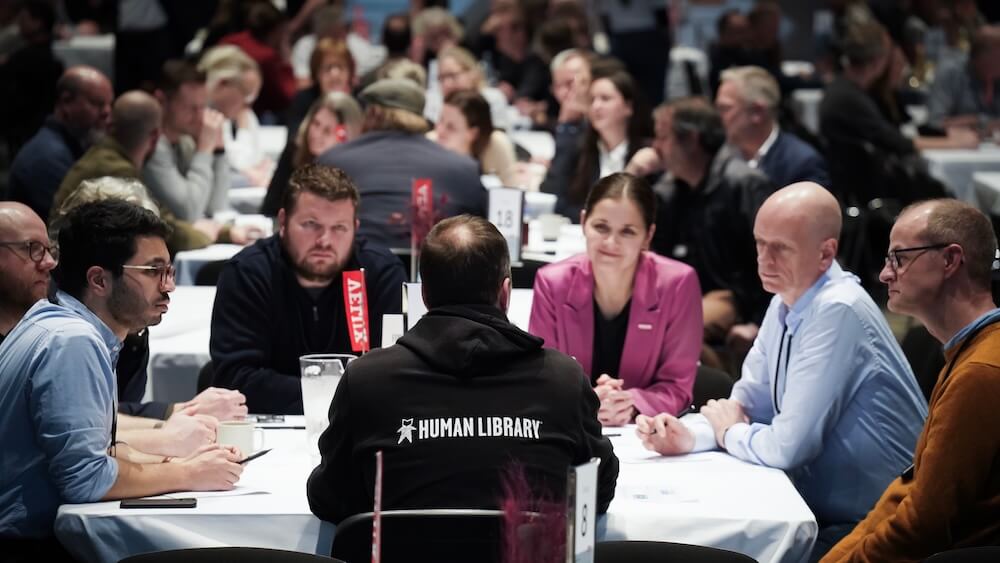 A ‘book’ speaks with ‘readers’ during an event for Danish manufacturing company Velux, which featured more than 25 human books for 500 employees in 2024. Photo courtesy VELUX